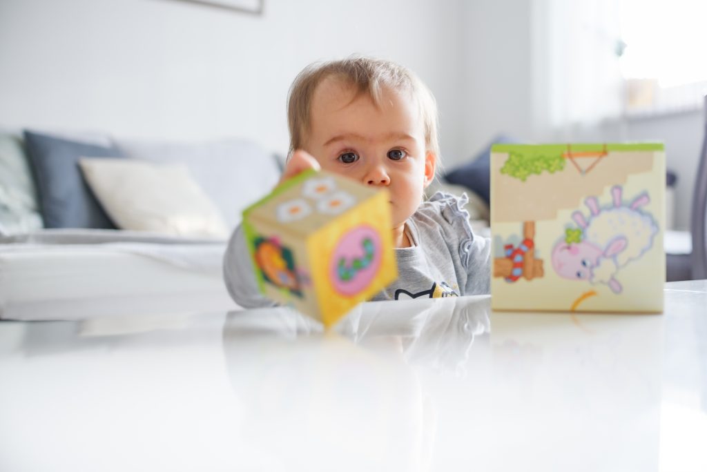 bebê brincando no chão com brinquedo sensorial