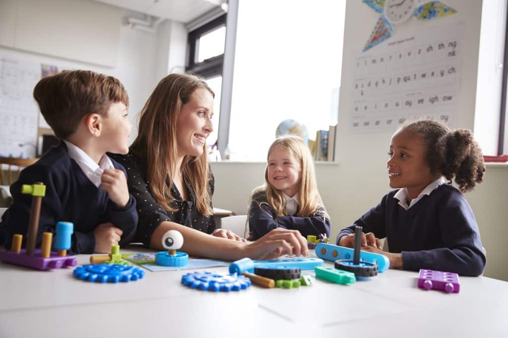 Professora estimula crianças com brinquedos pedagógicos.