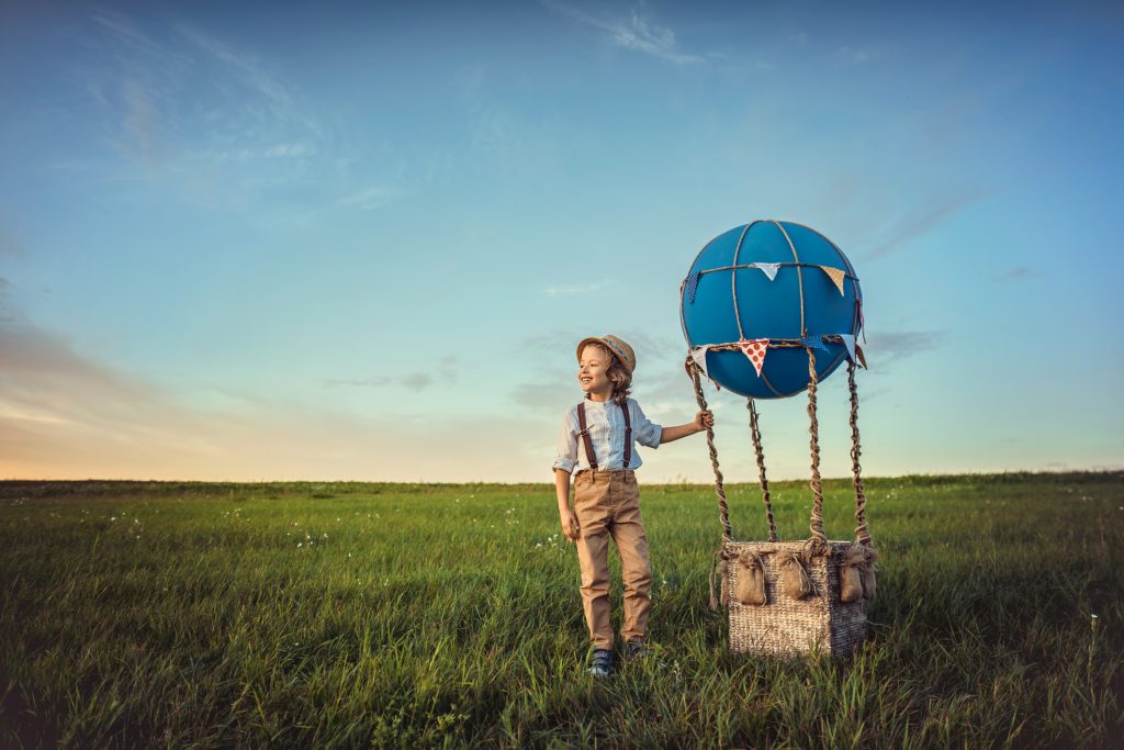 Menino no campo, brincando com balão.