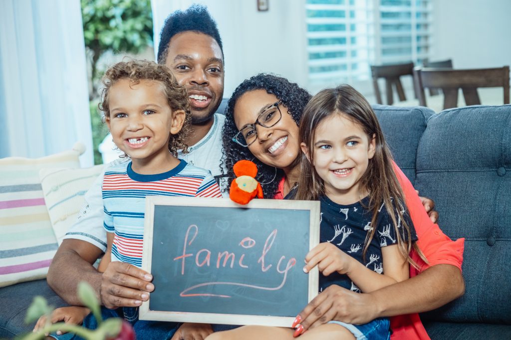 Família brinca com seus filhos em casa.